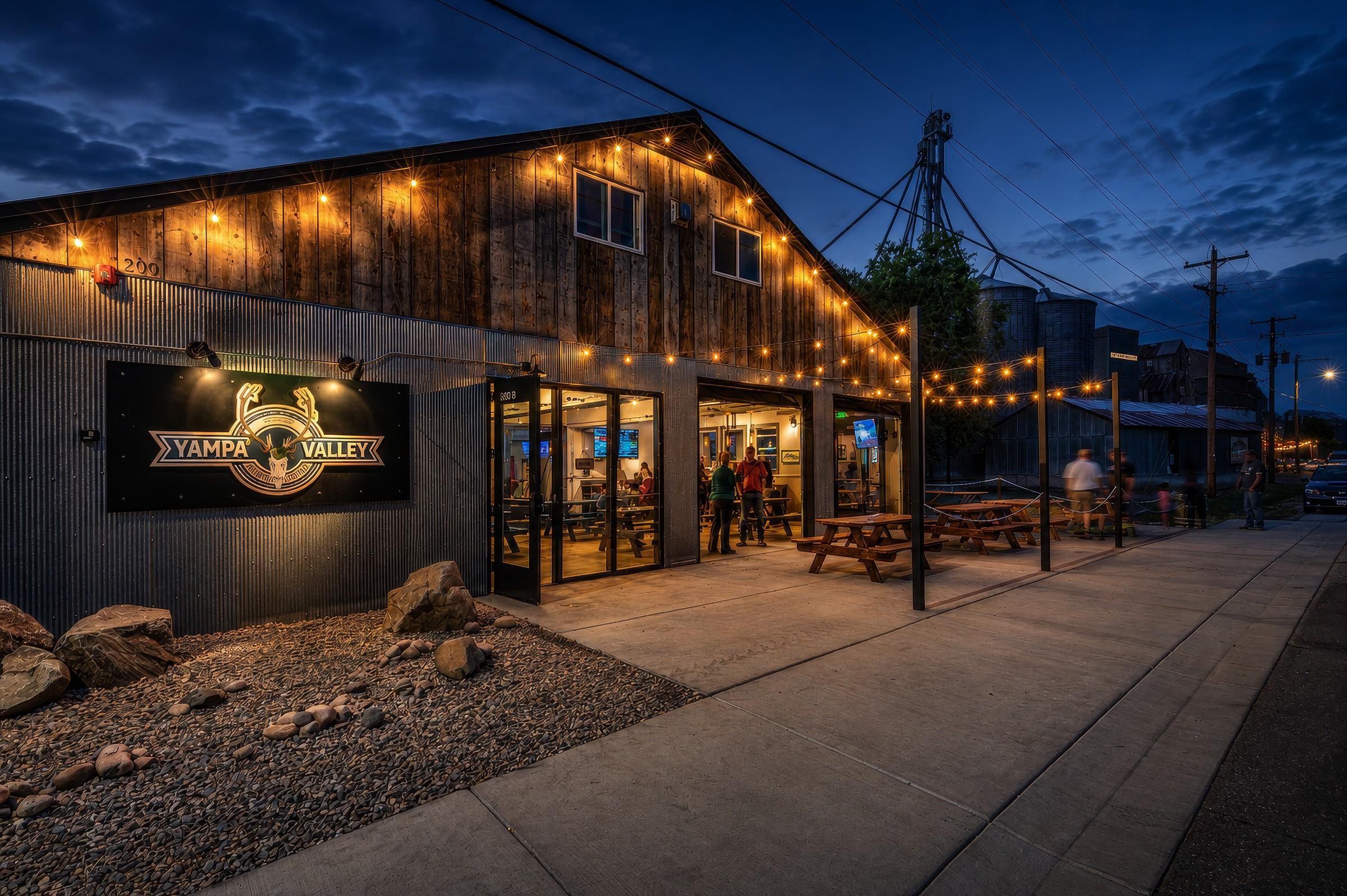 Brewery exterior at dusk with string lights
