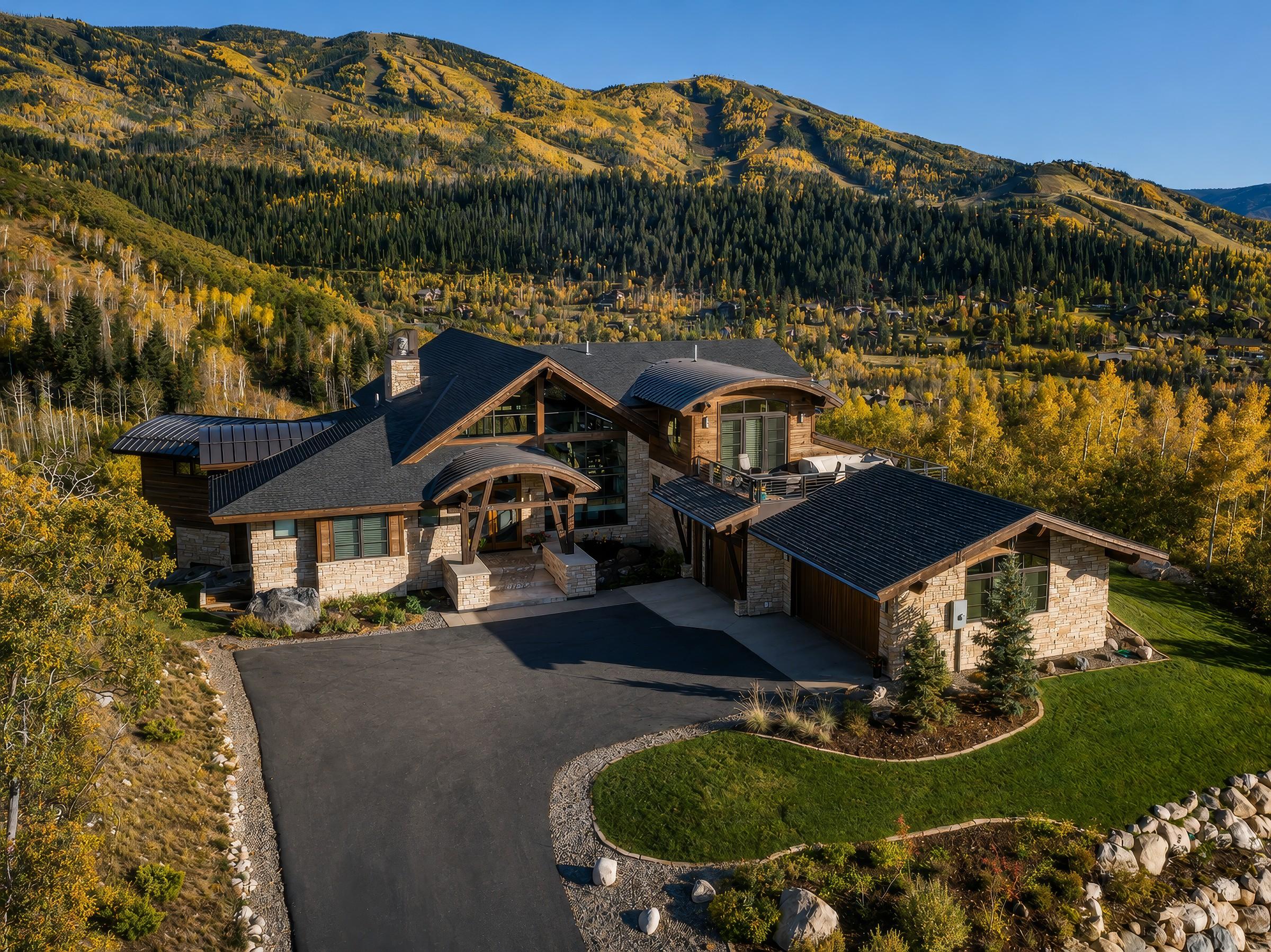 Mountain home exterior, aerial view in daylight with autumn color