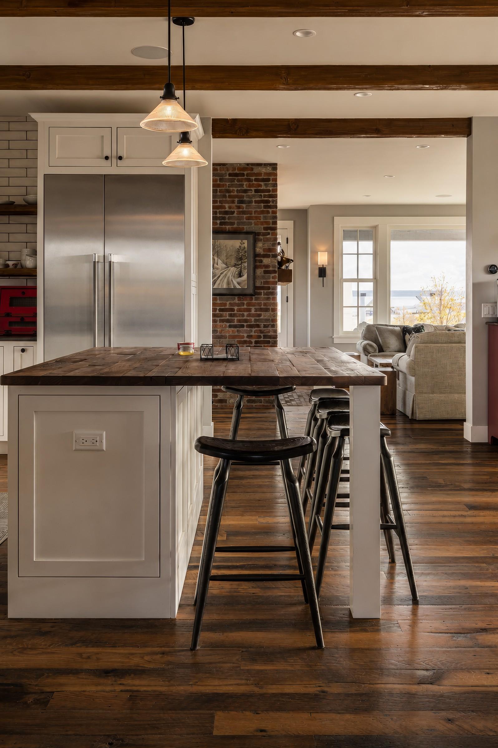 Kitchen island with brick accent wall and exposed wood beams