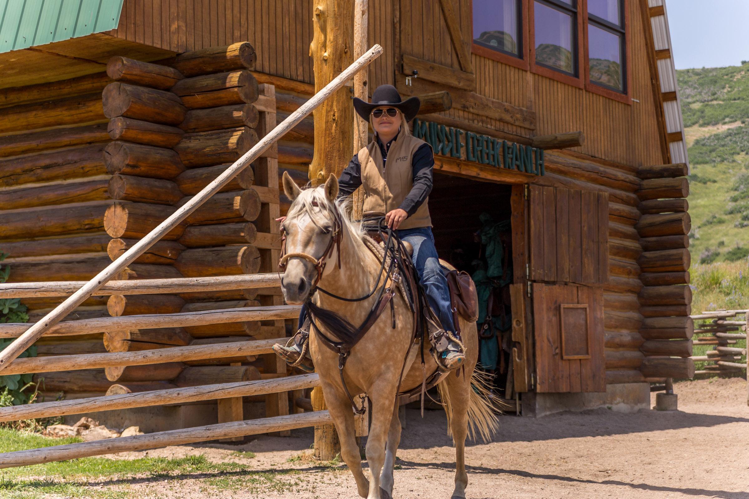 Portrait of a horseback rider at a ranch entrance
