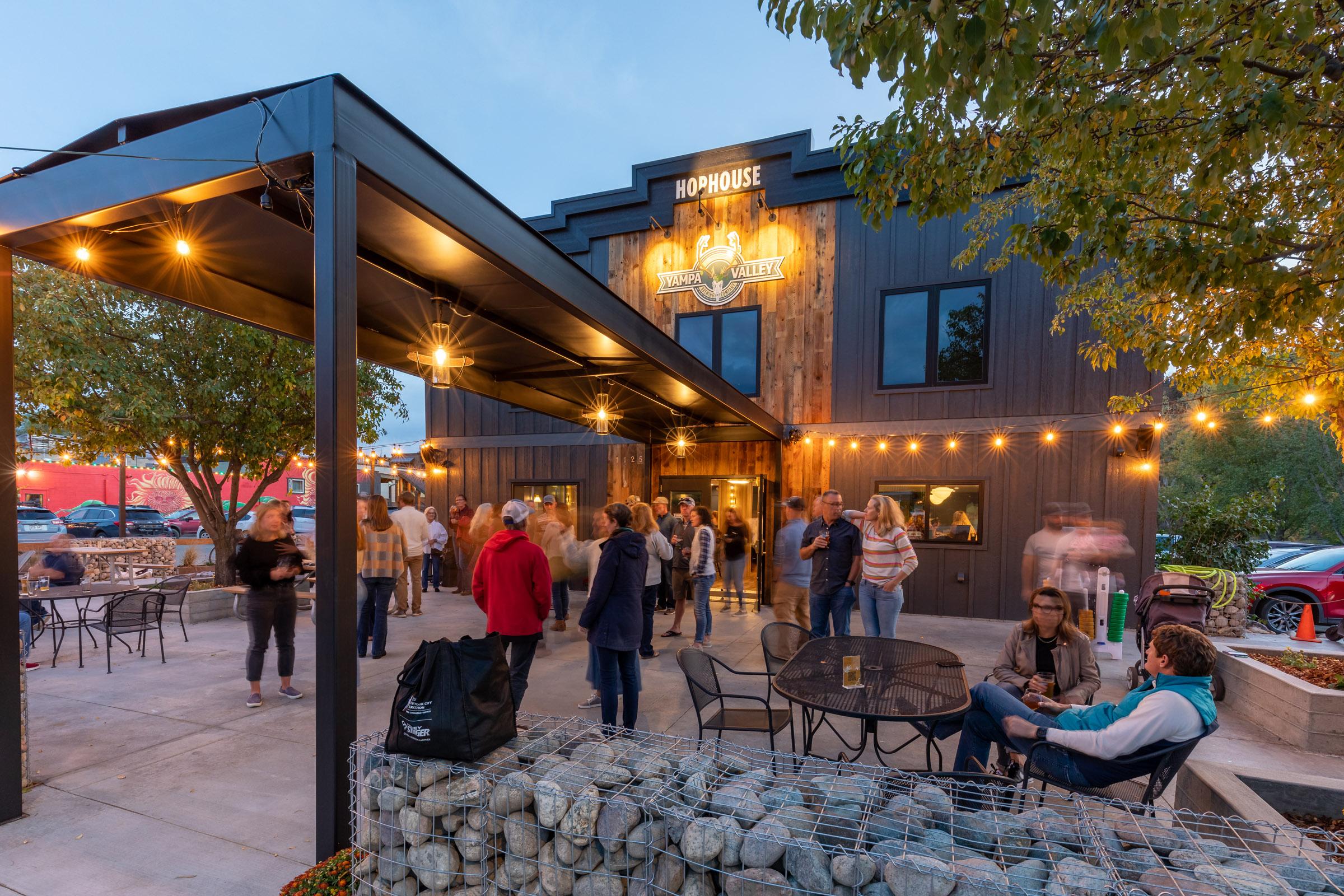 Taproom patio crowd in the evening with string lights